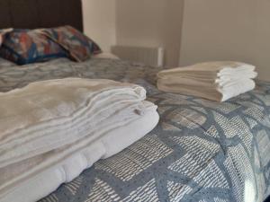 a bed with white sheets and pillows on it at The Old Fire Station at Colerne in Chippenham