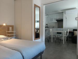 1 dormitorio con cama, mesa y cocina en Villa Esterel Plage, en Saint-Raphaël