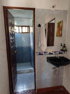 y baño con lavabo y ducha. en HERMOSA CABAÑA VILLA JULIA MESA DE LOS SANTOS, en Piedecuesta