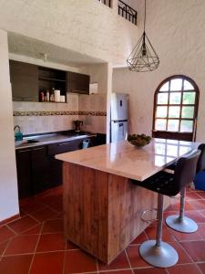una cocina con una isla de madera con encimera en HERMOSA CABAÑA VILLA JULIA MESA DE LOS SANTOS, en Piedecuesta