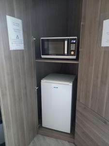 eine Küche mit einer Mikrowelle und einem kleinen Kühlschrank in der Unterkunft La fermette - chambres d'hôtes dans environnement calme et arboré in Saint-Jean-des-Baisants