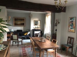 - un salon avec une table et des chaises en bois dans l'établissement La Maison des trois forêts, à Ermenonville