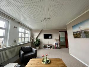 sala de estar con sofá y mesa en Ferienwohnung Eulenhof -direkt an der Este, en Jork
