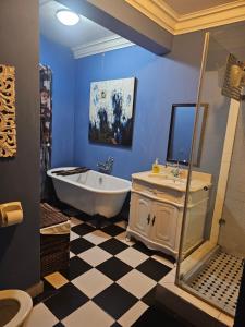ein Badezimmer mit einer Badewanne und einem Waschbecken in der Unterkunft Castle Home in Centurion