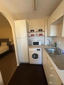 a small kitchen with a sink and a microwave at One bedroom flat and spare bed in Bristol