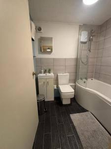 a bathroom with a toilet and a tub and a sink at One bedroom flat and spare bed in Bristol