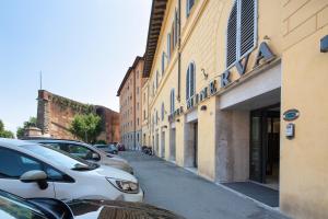 une rue avec des voitures garées sur le côté d'un bâtiment dans l'établissement Hotel Minerva, à Sienne
