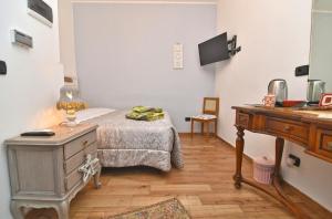 Dormitorio con cama, escritorio y TV en stanza romantica en Brandizzo