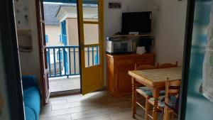 Joli studio avec balcon donnant sur la montagne في سانت-ماري-دي-كامبان: غرفه بطاوله وتلفزيون وبلكونه