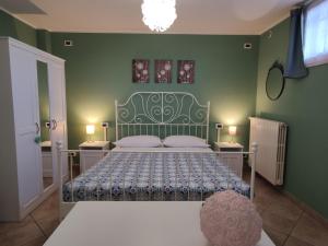 a bedroom with a bed with a green wall at La Tavernetta in Torriana
