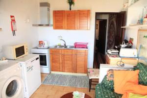 a kitchen with a washing machine and a living room at Casa Formiga RC2 in Porches