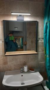 Joli studio avec balcon donnant sur la montagne في سانت-ماري-دي-كامبان: شخص يأخذ صورة مرآة على حوض