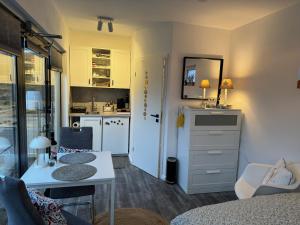 a living room with a table and a kitchen at Studio Dorfblick in Fehmarn