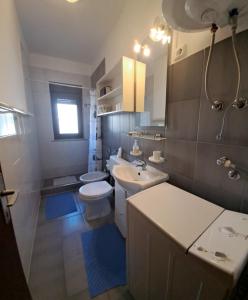La salle de bains est pourvue d'un lavabo blanc et de toilettes. dans l'établissement Apartments Finera, à Pomer
