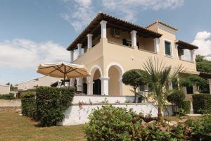 a large house with an umbrella in front of it at Villa Diana in Acharavi