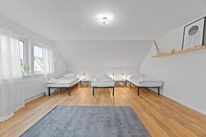 a white room with three chairs and a rug at W02 Business Apartment für Teams in Wendlingen am Neckar