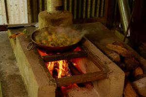 un pot de nourriture est préparé sur une cuisinière dans l'établissement Rancho Costafalo Eco-Tourism Farm, à Quebrada Grande
