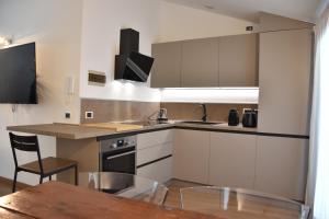a kitchen with white cabinets and a wooden table at Il riccio in Lovere