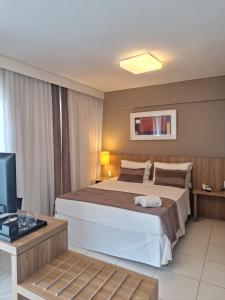 a bedroom with a large bed and a television at Rio stay Residence Flat Com Wi-Fi e Cozinha in Rio de Janeiro