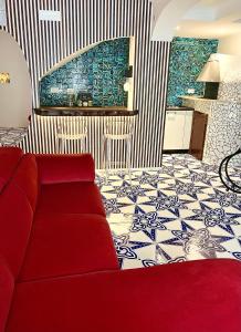 sala de estar con sofá rojo y suelo de baldosa en Vinny's Relais - Deluxe rooms & Suite en Vietri