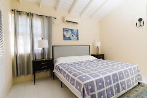 a bedroom with a bed and two night stands and a window at 2 Bedroom Apartment at Maynards in Saint Peter