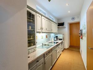 a kitchen with white cabinets and a sink at Ferienhaus am Ringweg in Bad Schandau