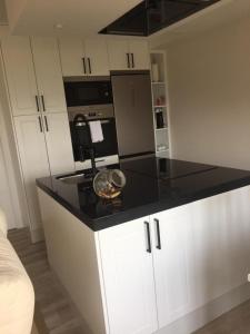 a kitchen with a black counter top and white cabinets at La casita de la abuela in Moaña