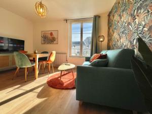 a living room with a blue couch and a table at Le TerraVerde - SOnights in Château-du-Loir