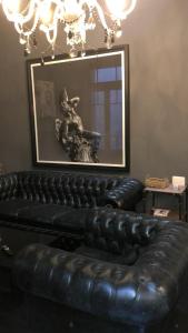 a black leather couch in a room with a picture at Balcarce in Buenos Aires