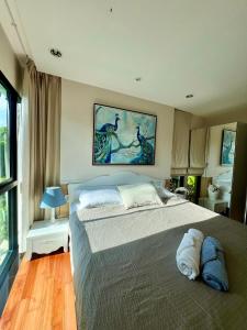 1 dormitorio con 1 cama grande y una pintura en la pared en The Title Rawai: Beachfront condotel en Rawai Beach