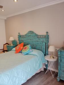 a bedroom with a blue bed with two pillows at El Balcón de La Juderia in Córdoba