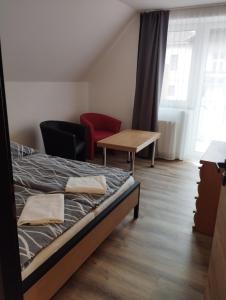 1 dormitorio con 1 cama, 1 mesa y 1 silla en Penzion Kormorán, en Vranov nad Dyjí