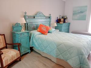 a bedroom with a blue bed and two night stands at El Balcón de La Juderia in Córdoba