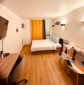 a small room with a bed and a desk with chairs at Ryan Homes Studio - in Aparthotel, La Défense in Courbevoie