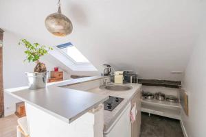 biała kuchnia ze zlewem i oknem w obiekcie Amazing location only 3 minutes from Luxembourg Gargens w Paryżu