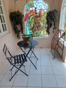 een tafel en stoelen in een kamer met een raam bij Hunter's Place - Tim Pappies in Port Antonio