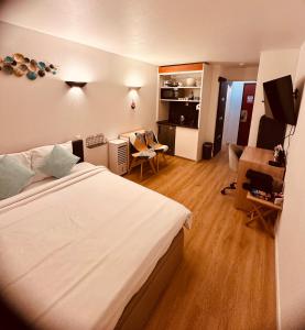 a hotel room with a large bed and a desk at Ryan Homes Studio - in Aparthotel, La Défense in Courbevoie