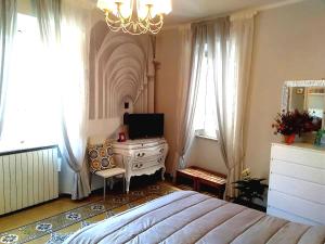 een slaapkamer met een bed, een dressoir en een spiegel bij tita's house in Lucca