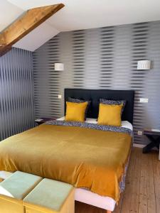 - une chambre avec un grand lit et des oreillers jaunes dans l'établissement Château de Courmelois Champagne Guest House, à Val de Vesle