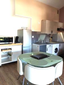 uma cozinha com uma mesa e cadeiras em Appartement T2 Argelès plage em Argelès-sur-Mer