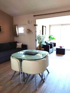 uma sala de estar com uma mesa de vidro e cadeiras em Appartement T2 Argelès plage em Argelès-sur-Mer