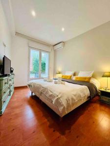ein Schlafzimmer mit einem großen Bett und einem großen Fenster in der Unterkunft « Côté jardin » Central/Piscine/Jacuzzi/Parking in Carcassonne