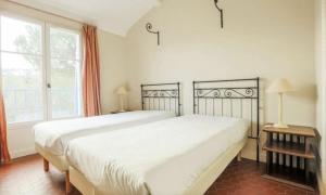 een slaapkamer met een groot wit bed en een raam bij One Palm in Grimaud