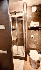 a bathroom with a shower and a toilet at Ryan Homes Studio - in Aparthotel, La Défense in Courbevoie