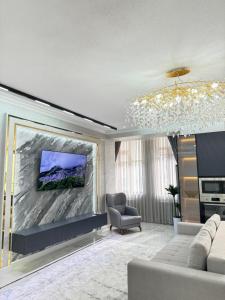 a living room with a couch and a tv on a wall at Lux 3-roomed apartment close to the Registan Amaliapartment in Samarkand