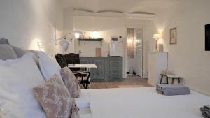 a bedroom with a white bed and a kitchen at Store Ejlstrup Bed & Breakfast in Odense