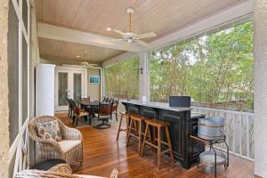 a screened in porch with a table and chairs at The Coral Door Beach House - 4315 Fourth Street in Saint Simons Island