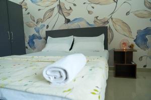 Un dormitorio con una cama con una toalla. en A/C room with Queen Bed Gachibowli, en Hyderabad
