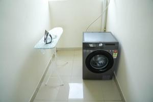 a washing machine in a room with a chair at A/C room with Queen Bed Gachibowli in Hyderabad