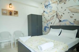 a bedroom with a bed with a painting on the wall at A/C room with Queen Bed Gachibowli in Hyderabad